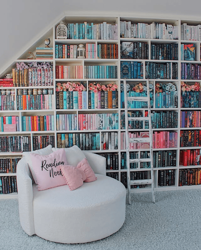 Color-Coded Bookshelf Wall Evoking Dreamy Reading Nook Vibes