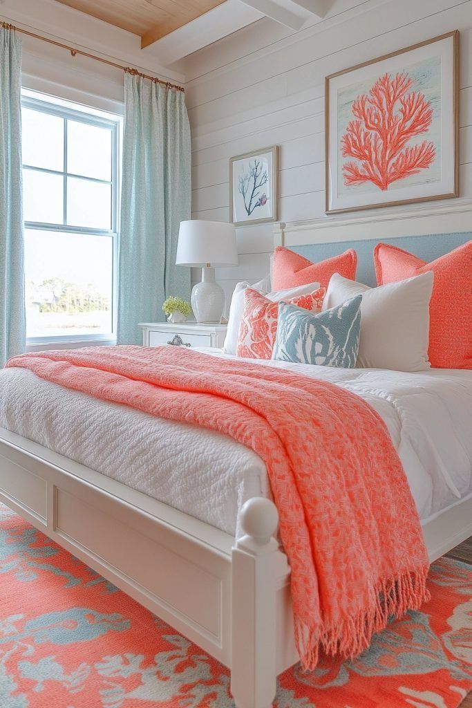 A bedroom features a white bed with coral throw and pillows, aqua curtains, and a matching rug.