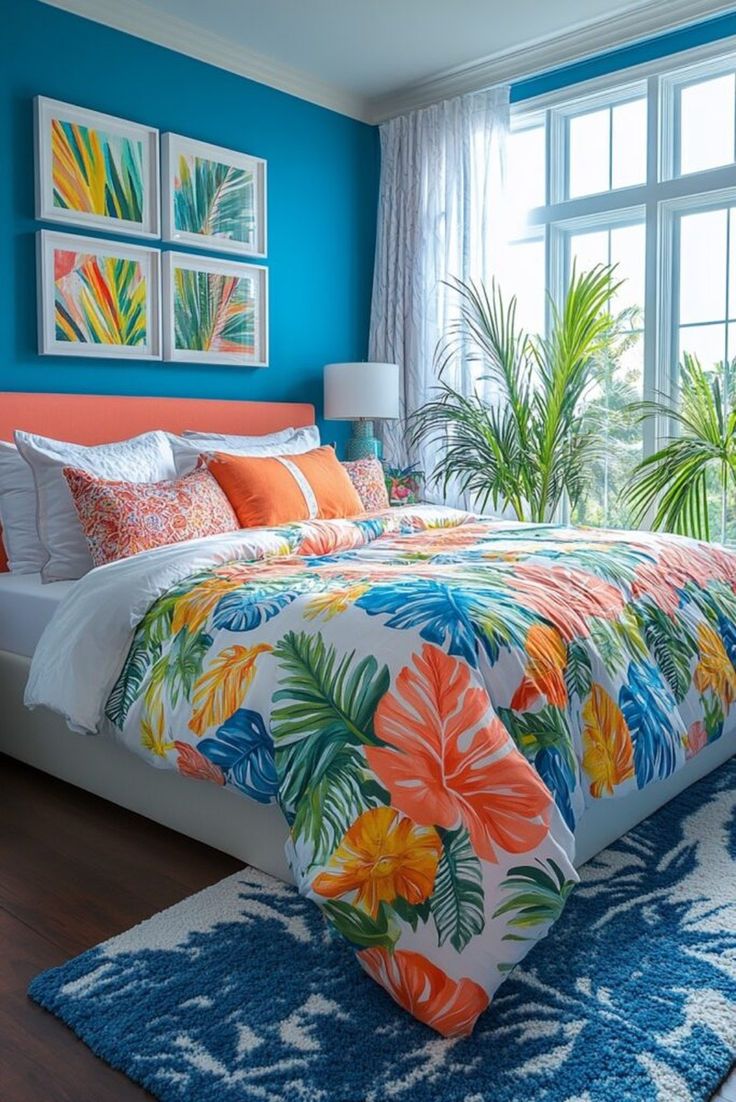 Bedroom with blue walls, tropical leaf duvet cover, orange headboard and pillows, and a large window.