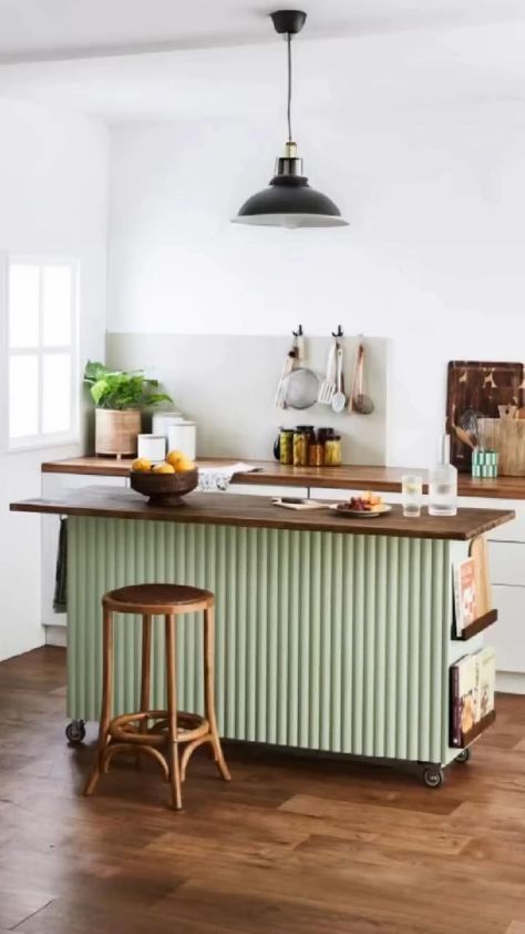 Kitchen island made from a light green slatted unit with a wooden countertop and bar stool, on wheels