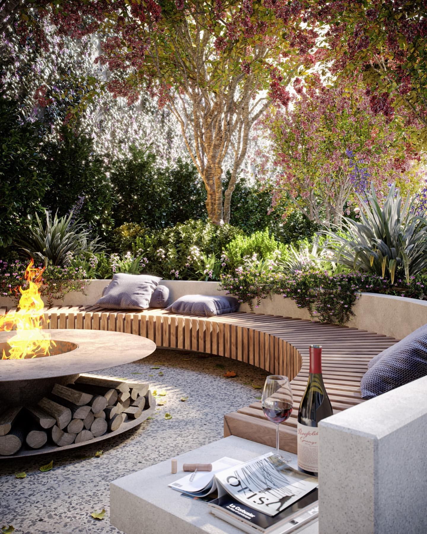 An outdoor fire pit with a blazing fire, surrounded by curved wooden slatted benches with grey cushions.
