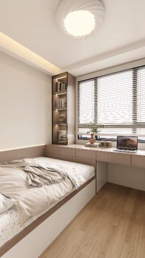 Small bedroom with a bed against the wall, an integrated desk and shelves next to a window, and wood flooring.