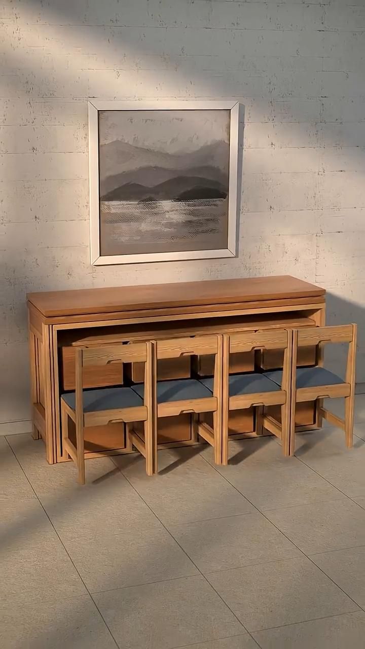 Wooden dining table with four matching chairs nested underneath, forming a compact console against a wall.