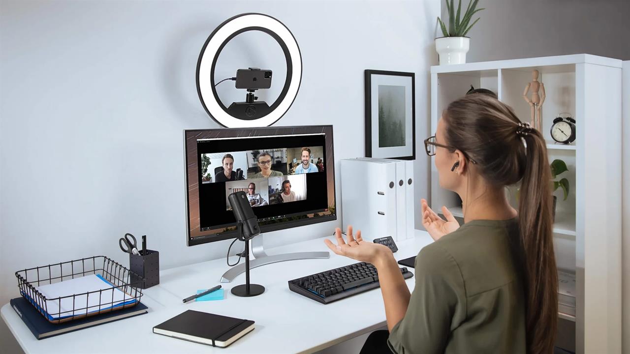 Ring light mounted above a computer monitor on a desk
