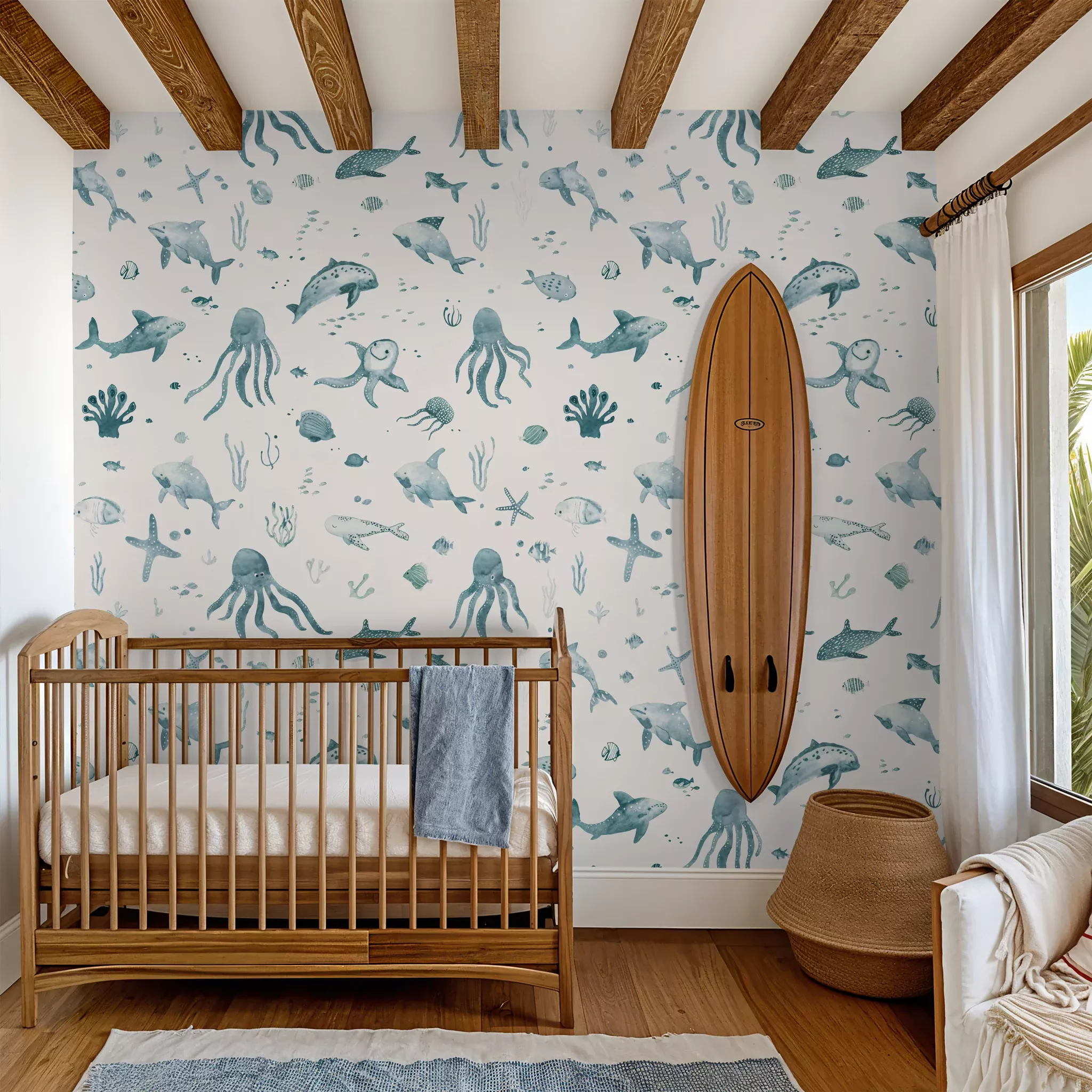 Nursery corner with a wooden crib, white walls with blue watercolor ocean animal wallpaper, and a wooden surfboard on the…