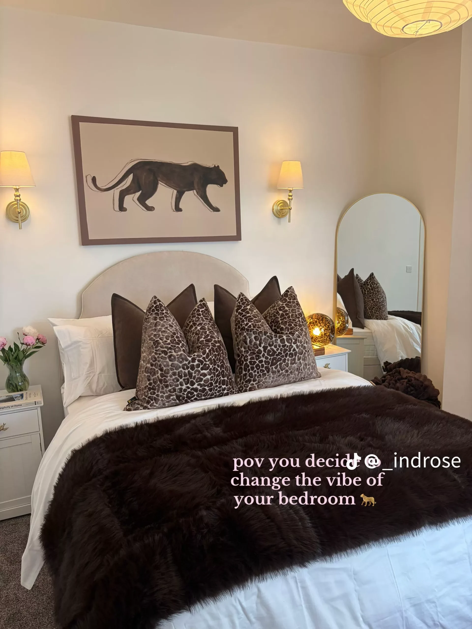 Bedroom with a beige headboard, dark brown faux fur throw, and leopard print pillows.