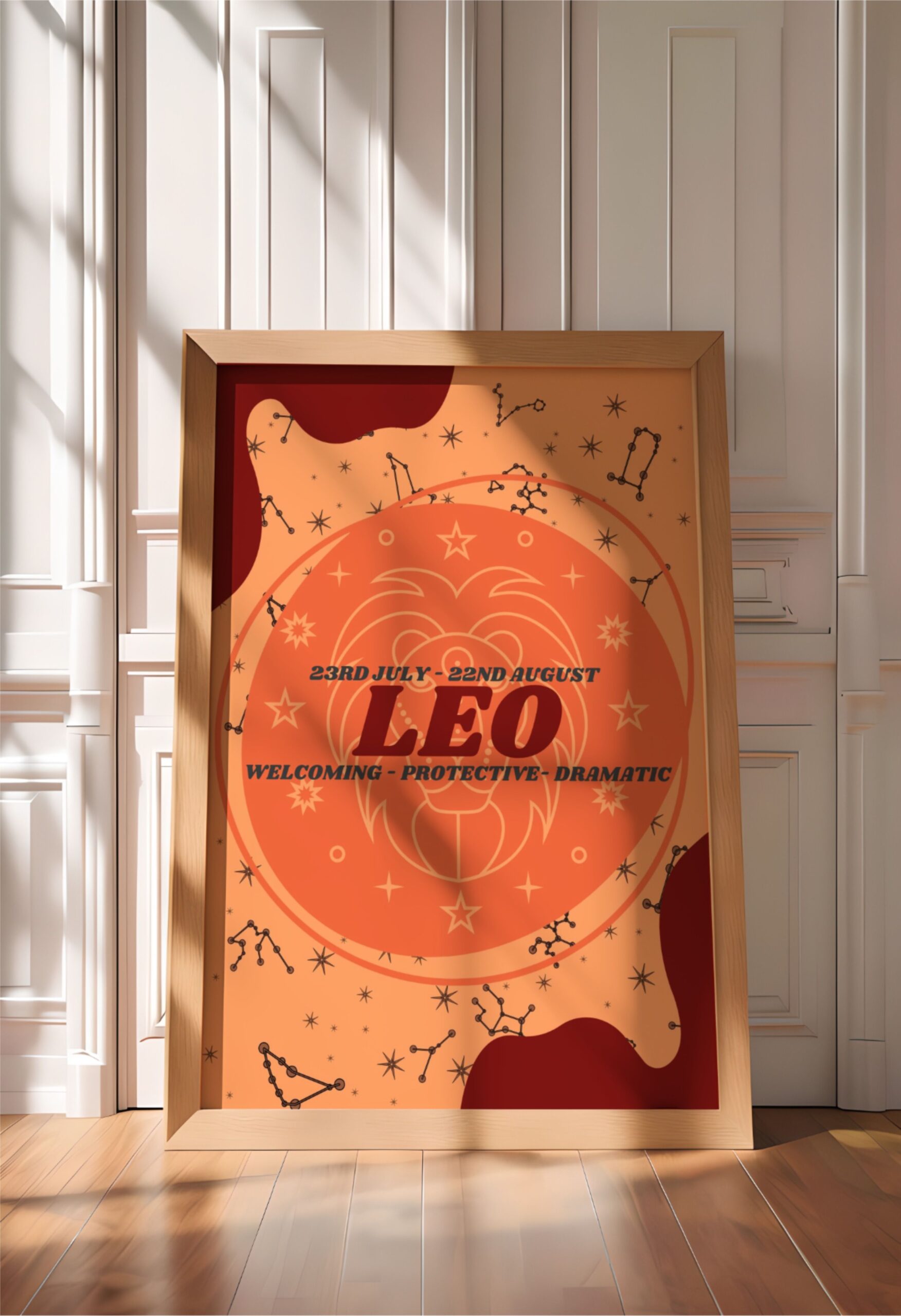 Leo zodiac art print in a light wood frame, leaning against a white paneled wall.