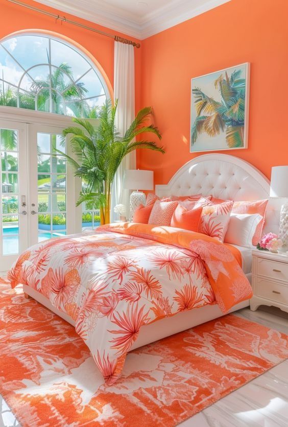 Bedroom with orange walls, a white tufted headboard, and tropical print bedding overlooking a pool.