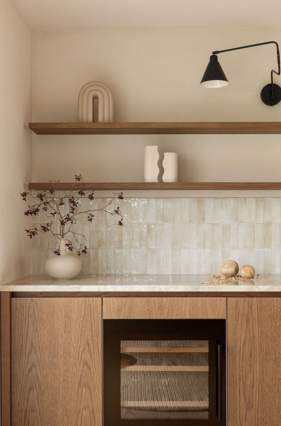 Kitchen counter with light wood cabinetry, stone counter, and a light-colored vertical tile backsplash.