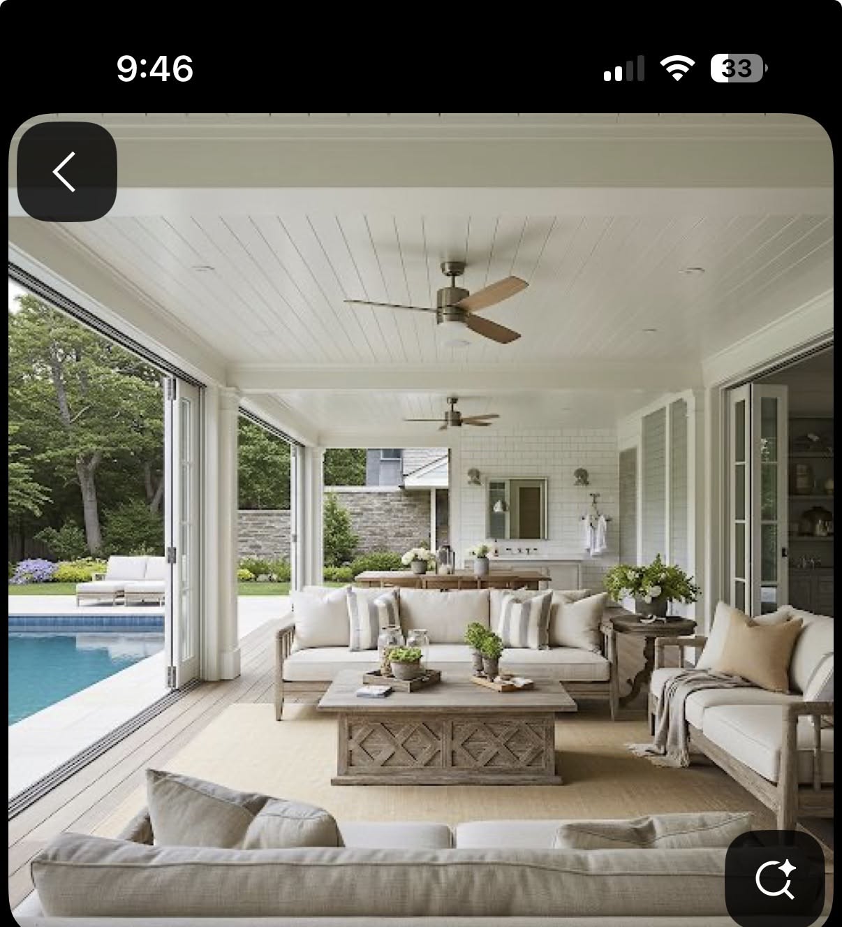 Covered patio with multiple seating areas, a coffee table, and an outdoor kitchen area next to a swimming pool.