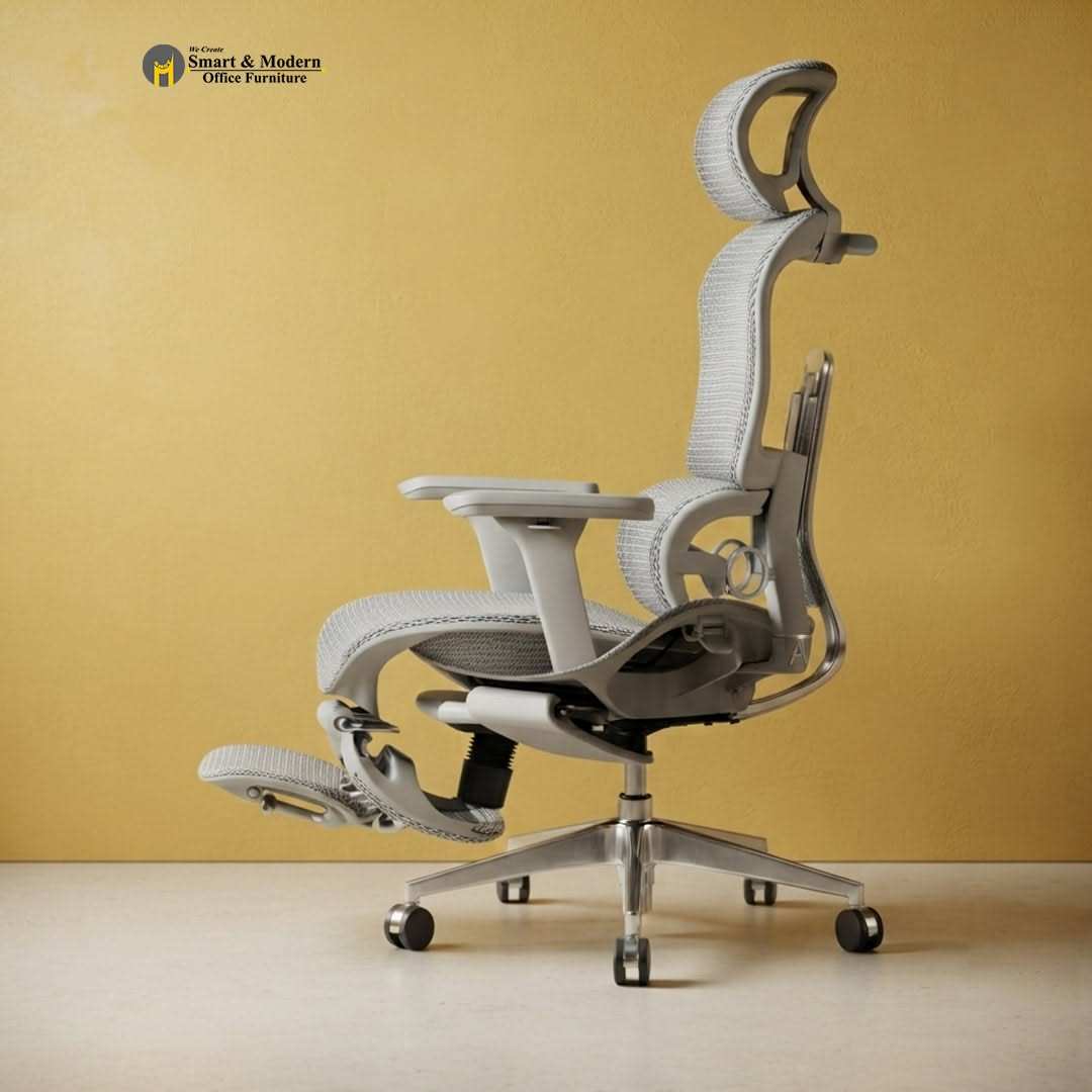 Light gray ergonomic office chair with headrest, mesh back, armrests, and a pull-out footrest