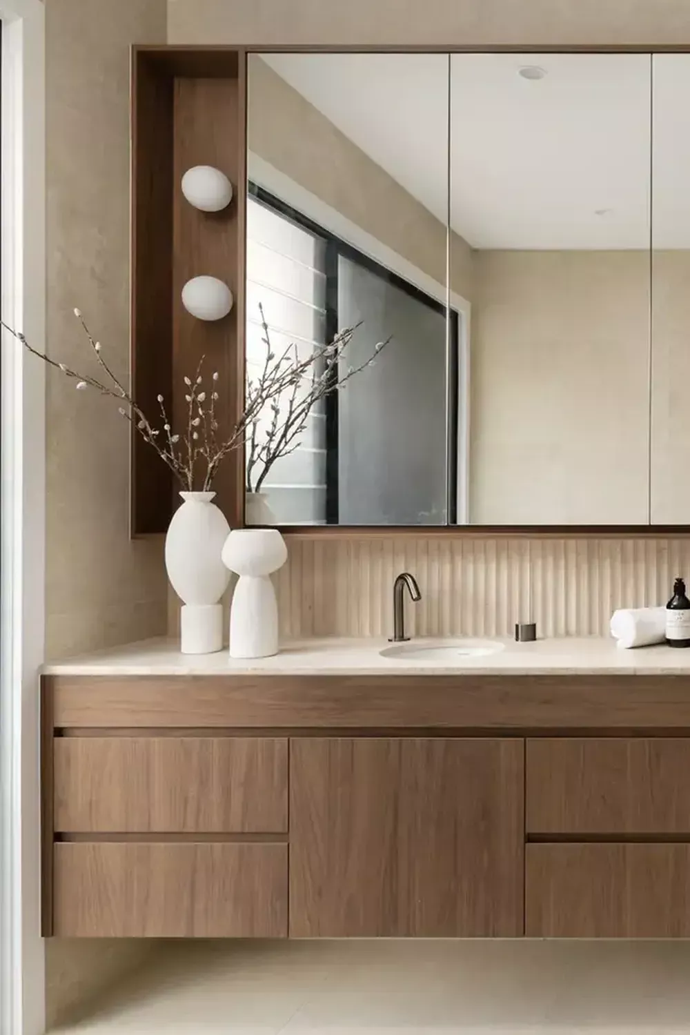 Floating wood bathroom vanity with a white countertop, oval sink, and mirror with built-in storage.
