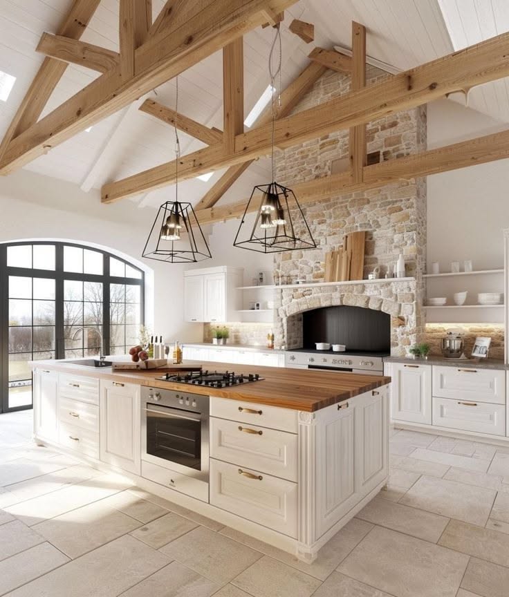 Bright, spacious kitchen with exposed wooden ceiling beams and a large stone fireplace above the stove.