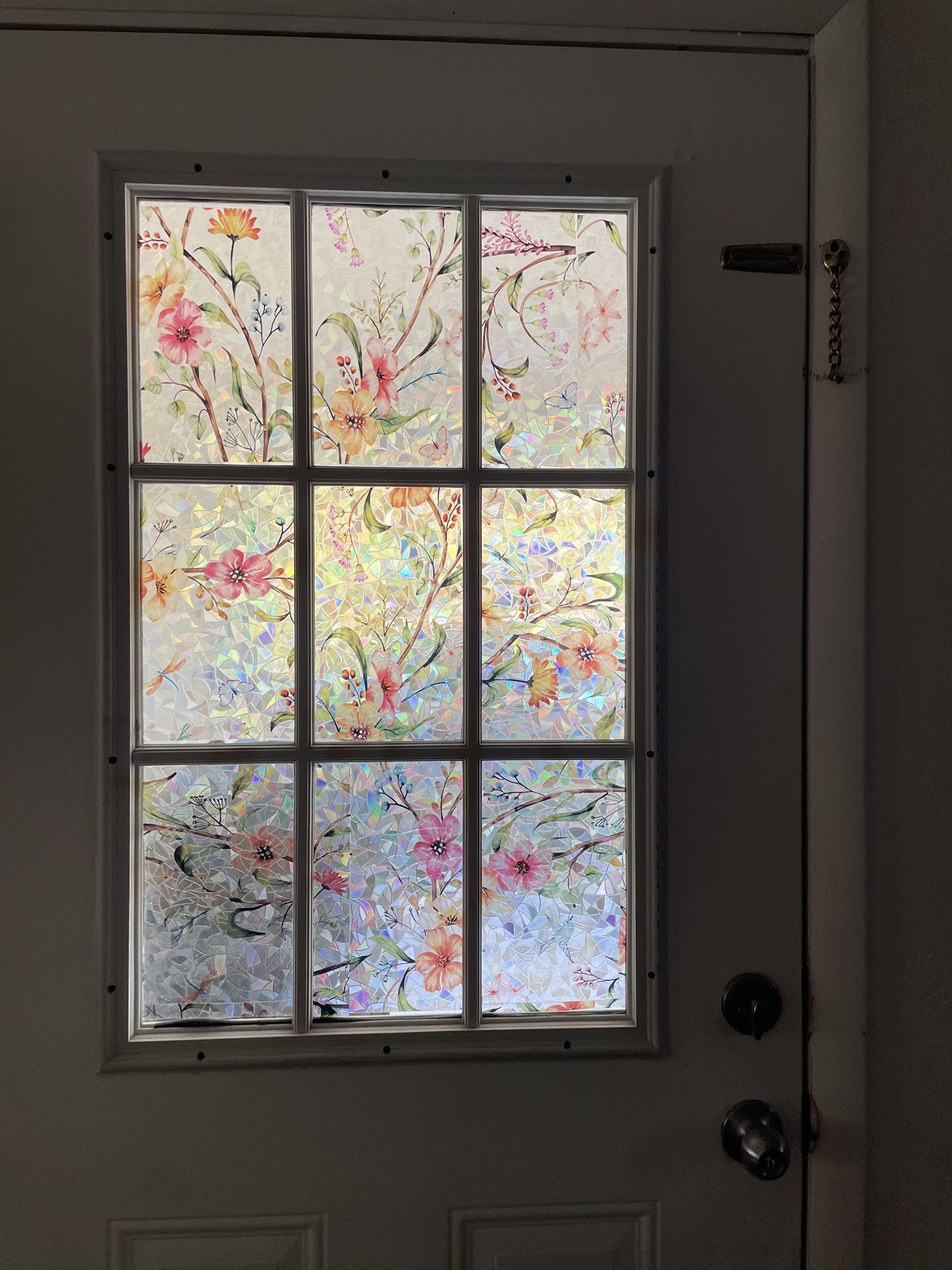Close-up view of a door with a window featuring a floral pattern static cling window film.