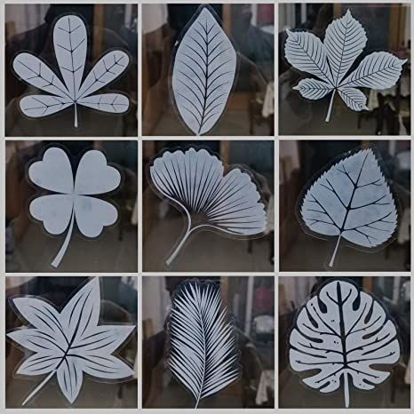 Collection of various white leaf-shaped decals adhered to a glass surface.