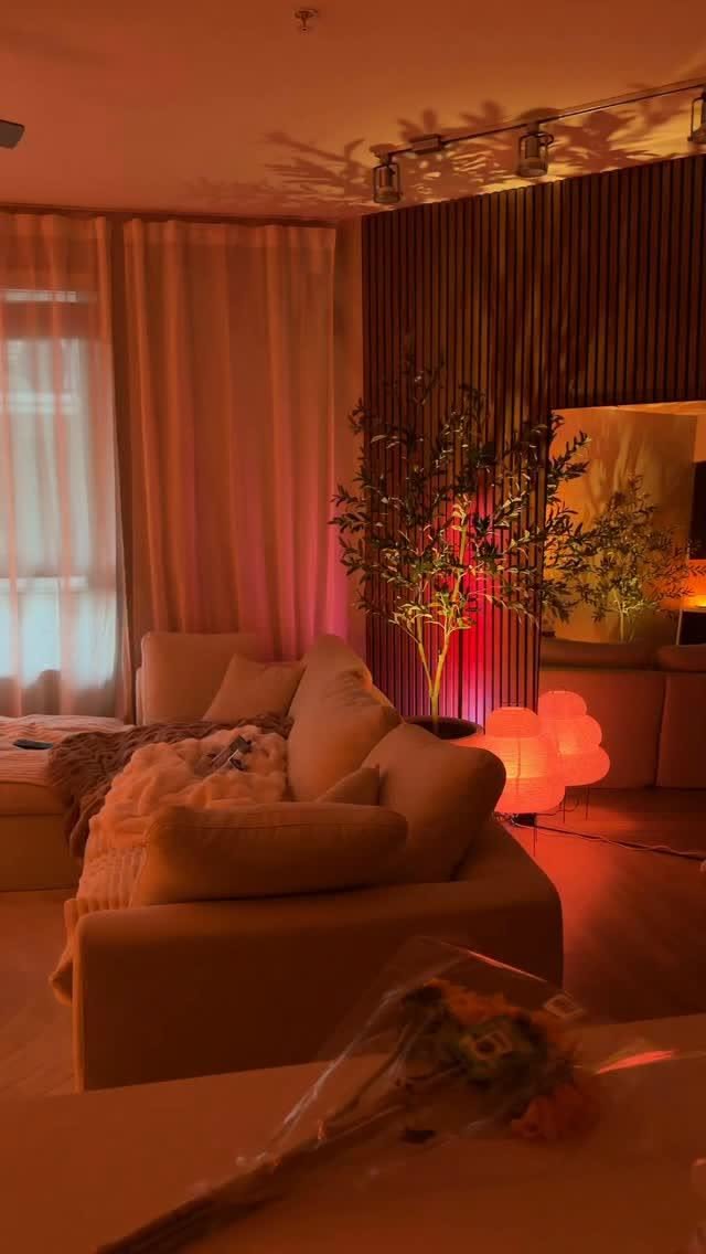 A living room at night with multiple warm lights on, creating a cozy and inviting atmosphere.