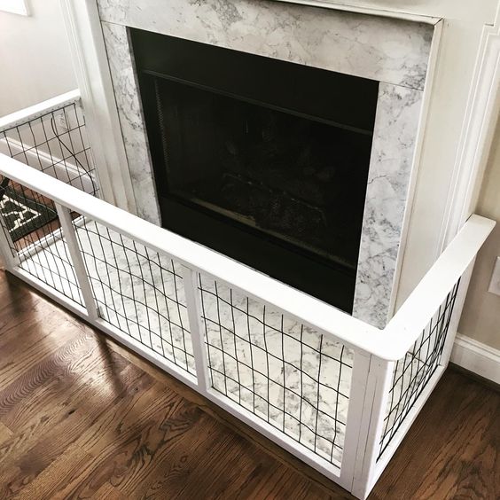 A wooden freestanding gate positioned across a stone fireplace hearth.