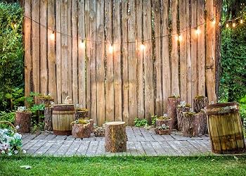 Printed backdrop showing wooden planks, string lights, and green plants
