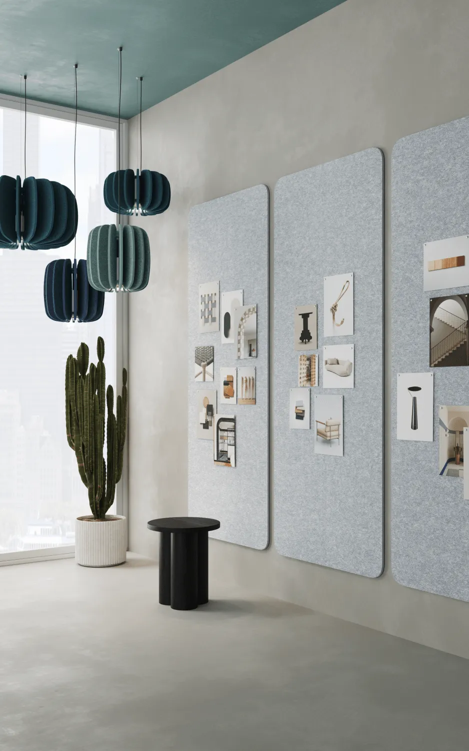 Three dark blue and green ribbed acoustic pendant lights hang from a teal ceiling in an office space with light gray…