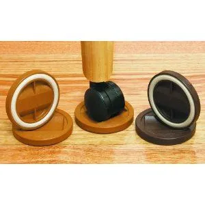Round, wooden caster cups in various shades, some with white felt rings, on a light wood floor next to a chair caster.